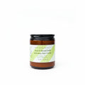 Jar of KAM Family Botanics Root & Strand Daily Softening Hair Cream on a surface with a blurred background